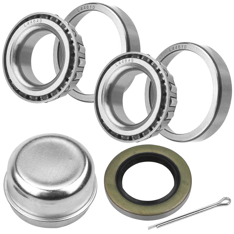 Trailer wheel bearing kit: two sets of tapered roller bearings, grease cap, rubber seal, and cotter pin. Silver bearings, black seal, and metal cap visible.